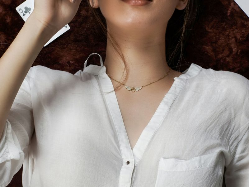 Mujer con camisa blanca y estética de naipes
